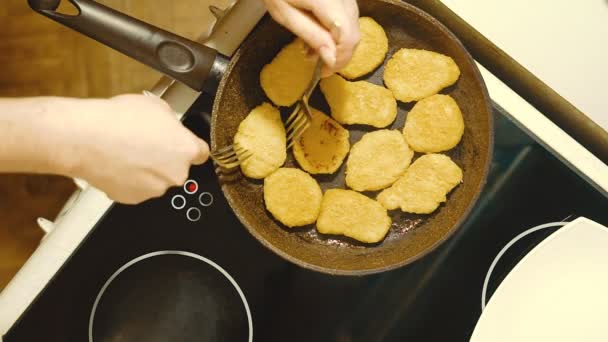 Preparation of cheese cakes at home. We turn the workpieces fried from one side to the other side. — Stock Video