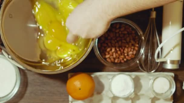 Haciendo un pastel dulce en casa. Revuelva las yemas y proteínas de los huevos de pollo a una masa homogénea . — Vídeos de Stock