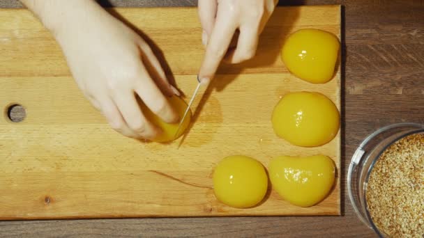 Close-up de mãos humanas cozinhar torta doce em casa. Pêssegos de redução em pequenas partes . — Vídeo de Stock