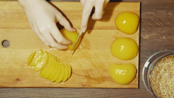 Fazendo uma torta doce em casa. Cortamos alguns pêssegos em pequenas partes . — Vídeo de Stock