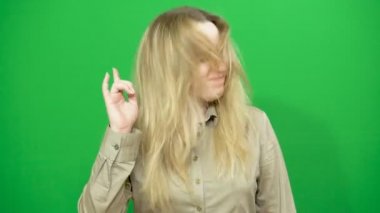 Genç kız poz. İyi bir ruh hali. Müzik keyfi ritmik hareketler yapar. Arka plan yeşil ekran.