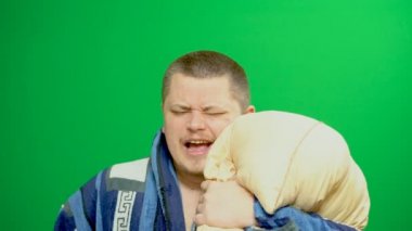 Uykulu bir genç adam. Ev bornoz. Yawns. O sabah çay içer.