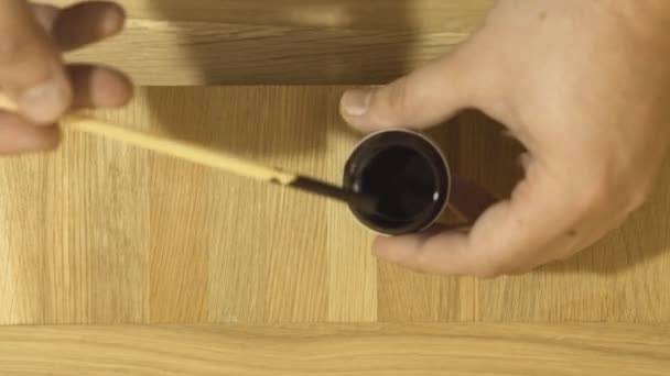 Close-up van mans hand lijnzaad behandeling van hout olie met verf aanbrengen. — Stockvideo