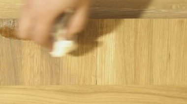 Ahşap bir yüzey üzerinde koruyucu bir tabaka uygulanması. Yakın çekim.