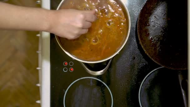 전기 스토브에 집에서 만든 수프 양조입니다. 우리는 약간의 소금을 추가합니다. — 비디오