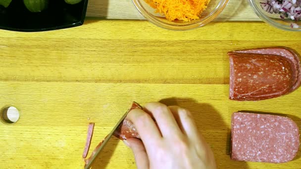 Крупный план человеческих рук, режущих полукопченую колбасу . — стоковое видео