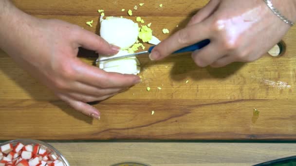 Fechar as mãos cortando ovo. Em uma placa de cozinha amarela . — Vídeo de Stock