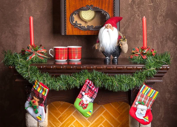 Christmas decoration of fireplace candles, garland and socks. — Stock Photo, Image