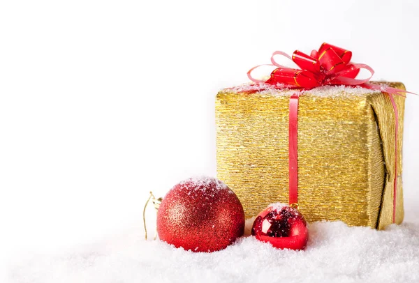 Bílá blahopřání s kopií prostoru pro vánoční a Silvestrovské zlaté zabalený dárek a červený míč na sněhu. Stock Fotografie