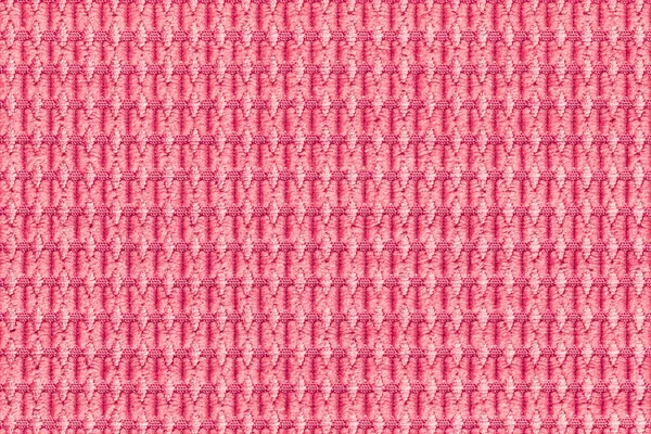 Light red background from soft fleecy fabric closeup. Texture of textiles macro.