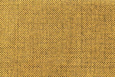 Dark yellow textile background with chess pattern, closeup. Structure of the fabric macro.
