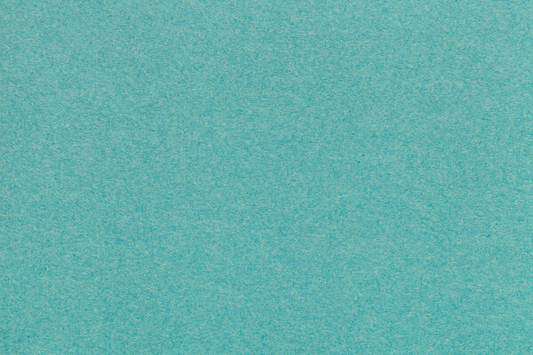 Texture of old turquoise paper closeup. Structure of a dense cardboard. The green background.