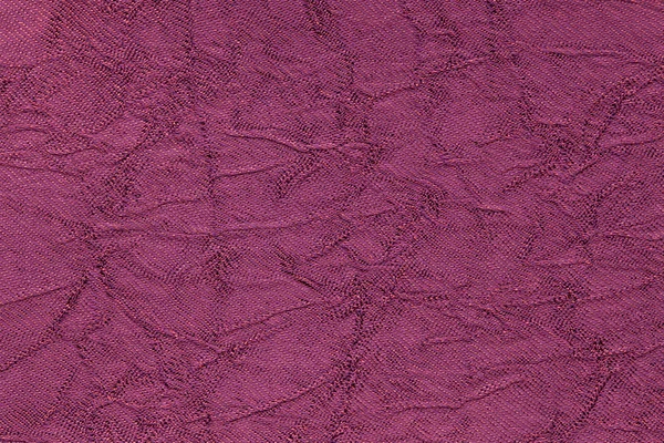 Donkere paarse golvende achtergrond van textiel materiaal. Stof met plooi textuur closeup. — Stockfoto