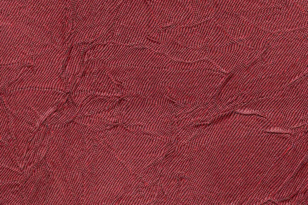 Fond ondulé rouge foncé à partir d'une matière textile. Tissu avec la texture de pli gros plan . — Photo