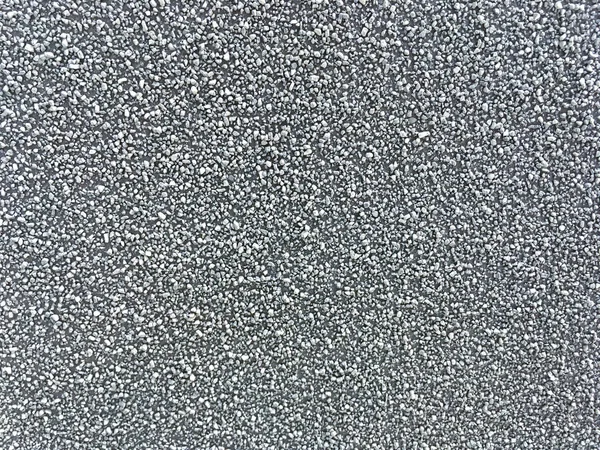 Achtergrond van verspreide grijze fijn grind. Textuur van een stenen ondergrond, close-up — Stockfoto