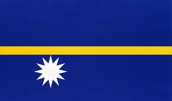 Köztársaság Nauru nemzeti szövet zászló, textil háttér. A világ óceáni országának szimbóluma. — Stock Fotó