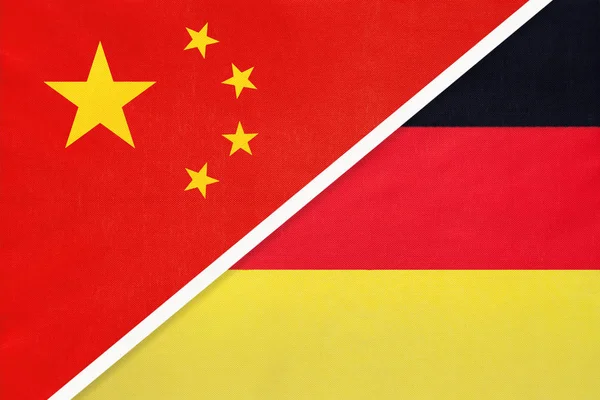 Китай або Прак проти німецького національного прапора з текстилю. Відносини між азійськими та європійськими країнами. — стокове фото