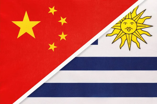 China oder Prc vs Uruguay Nationalflagge aus Textil. Beziehungen zwischen asiatischen und amerikanischen Ländern. — Stockfoto