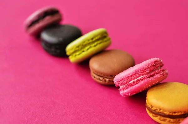 six macaroons on a pink background with a place under the text