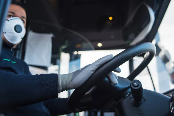 Koronavirüs salgınından korunmak için otobüste elinde koruyucu eldivenler olan genç İspanyol otobüs şoförü. Covid 19. Corona virüsünden koru. Karantina 2020, evde kal..