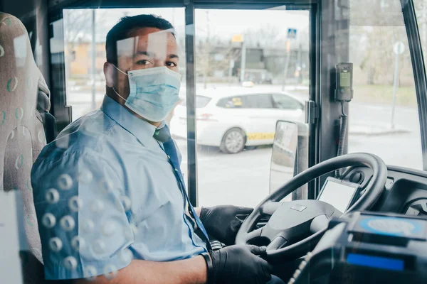 Maskeli otobüs şoförü kendini koronavirüs salgınından korumak için otobüste eline koruyucu eldiven takıyor. 2020 pandemik koronavirüs. Karantinaya alın. Virüs konsepti. Salgın hastalık.