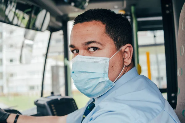 Ung Hispanic Busschaufför Bär Blå Mask Bussen För Att Skydda Stockbild