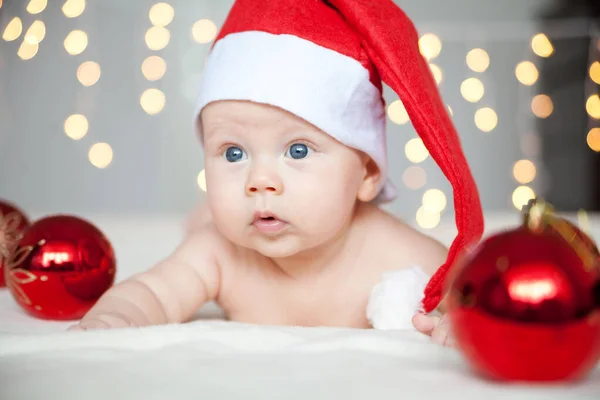 Christmas baby boy in Santa hat with red balls Stock Image
