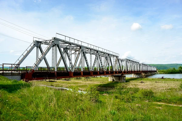 Puente ferroviario sobre el río, que fluye de las montañas en —  Fotos de Stock