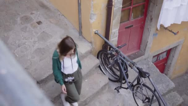 Giovane donna turistica sta camminando nella città vecchia, utilizzando la mappa di carta per navigare — Video Stock