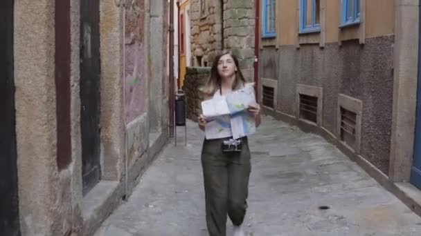 Mulher bonita viajante está andando na rua europeia, usando o mapa de papel — Vídeo de Stock