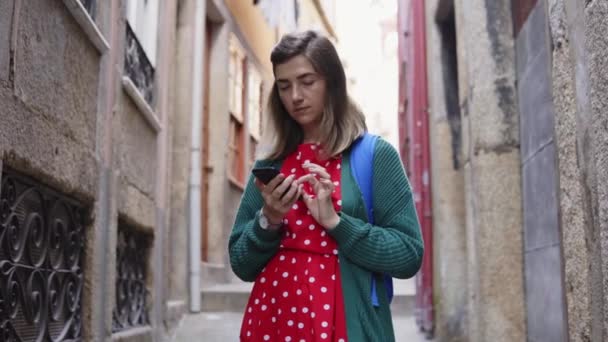 Jonge vrouw toerist staat in Old Street, op zoek naar haar weg in Navigator — Stockvideo