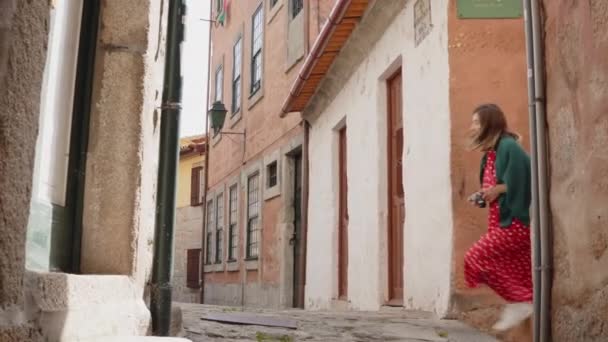 Mujer joven turista hace una parada para tomar una foto en la cámara Vintage — Vídeo de stock