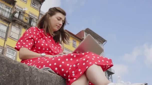 Mujer joven freelancer está trabajando en el ordenador portátil en el muelle del río — Vídeos de Stock