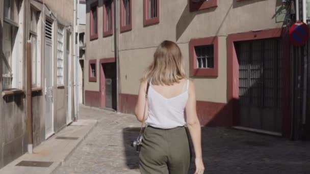 Νεαρή γυναίκα περπατά στην Ευρωπαϊκή πόλη, Θέα από πίσω — Αρχείο Βίντεο