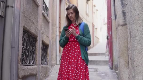 Pretty Woman Tourist está de pé na rua velha europeia, usando seu telefone móvel — Vídeo de Stock