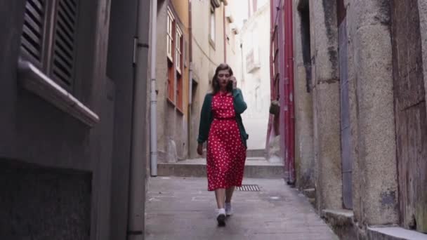 Mulher turista está andando em Old Narrow Street e conversando no telefone móvel — Vídeo de Stock