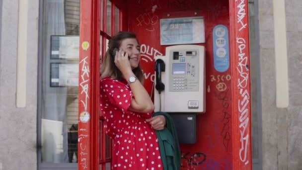 Mulher jovem está falando no telefone celular na caixa de telefone — Vídeo de Stock