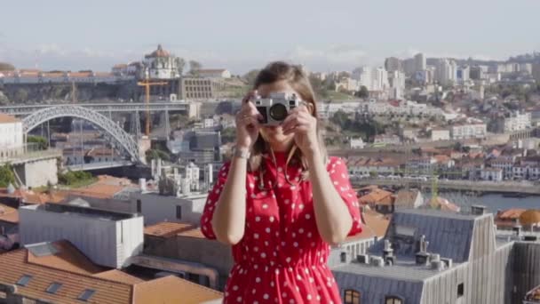 Mujer en vestido rojo está tomando una foto en la cámara Vintage — Vídeo de stock