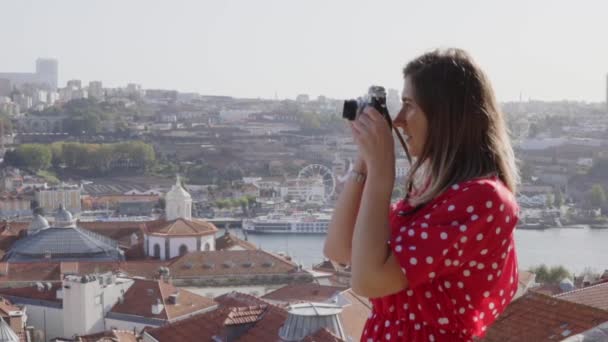Mujer en vestido rojo está tomando una foto de hermoso panorama urbano — Vídeo de stock