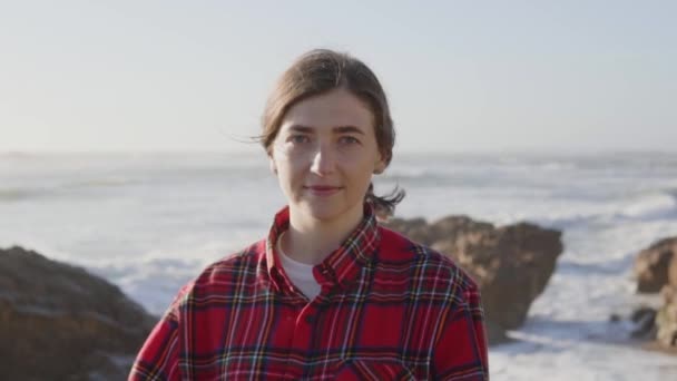 Retrato da jovem mulher em pé na praia rochosa — Vídeo de Stock