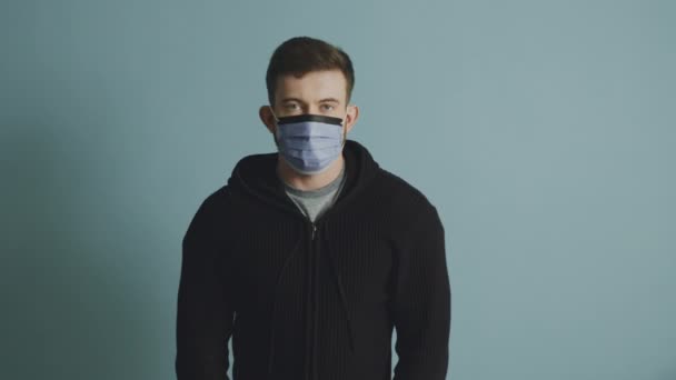 Portret van een jonge man in een beschermend masker dat kalm houdt — Stockvideo