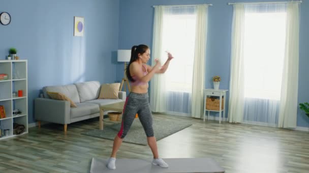 Mladý fit žena je cvičení s brumbály — Stock video