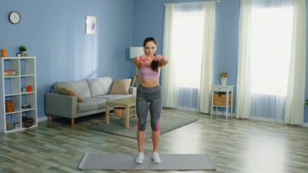 Mujer joven está haciendo ejercicio de brazo en casa — Vídeo de stock