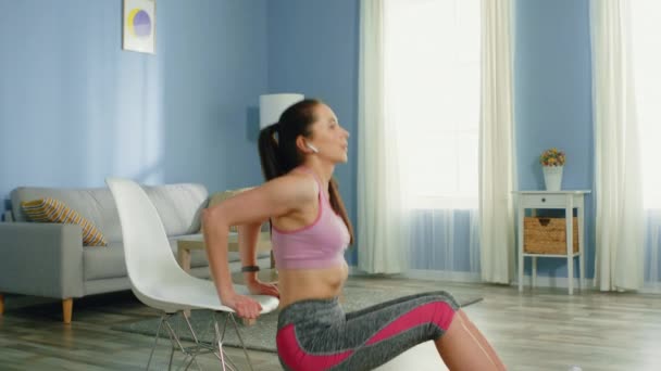 Mujer joven está entrenando con silla de plástico — Vídeos de Stock