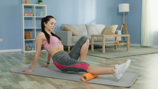 Young Woman Is Doing Leg Massage With the Help of Foam Roller — Stock Video