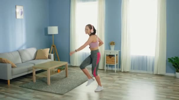 Joven mujer en forma está bailando en casa — Vídeo de stock