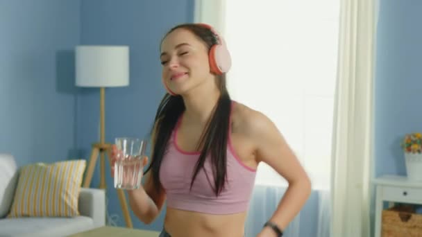Pretty Woman tańczy i trzyma szklankę wody — Wideo stockowe