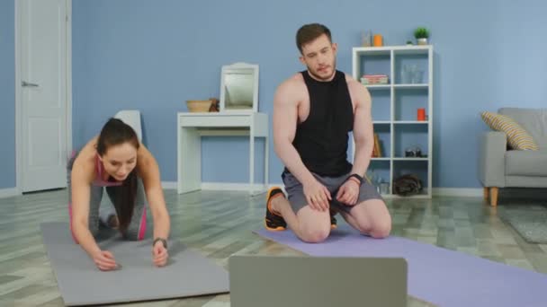 Mladý pár je cvičení doma sledování online školení videa — Stock video