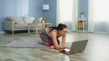 Genç Kadın Çevrimiçi Fitness Uygulamasını Kullanarak Çalışıyor