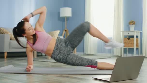 Jovem mulher forte está fazendo exercício online em pé na prancha — Vídeo de Stock